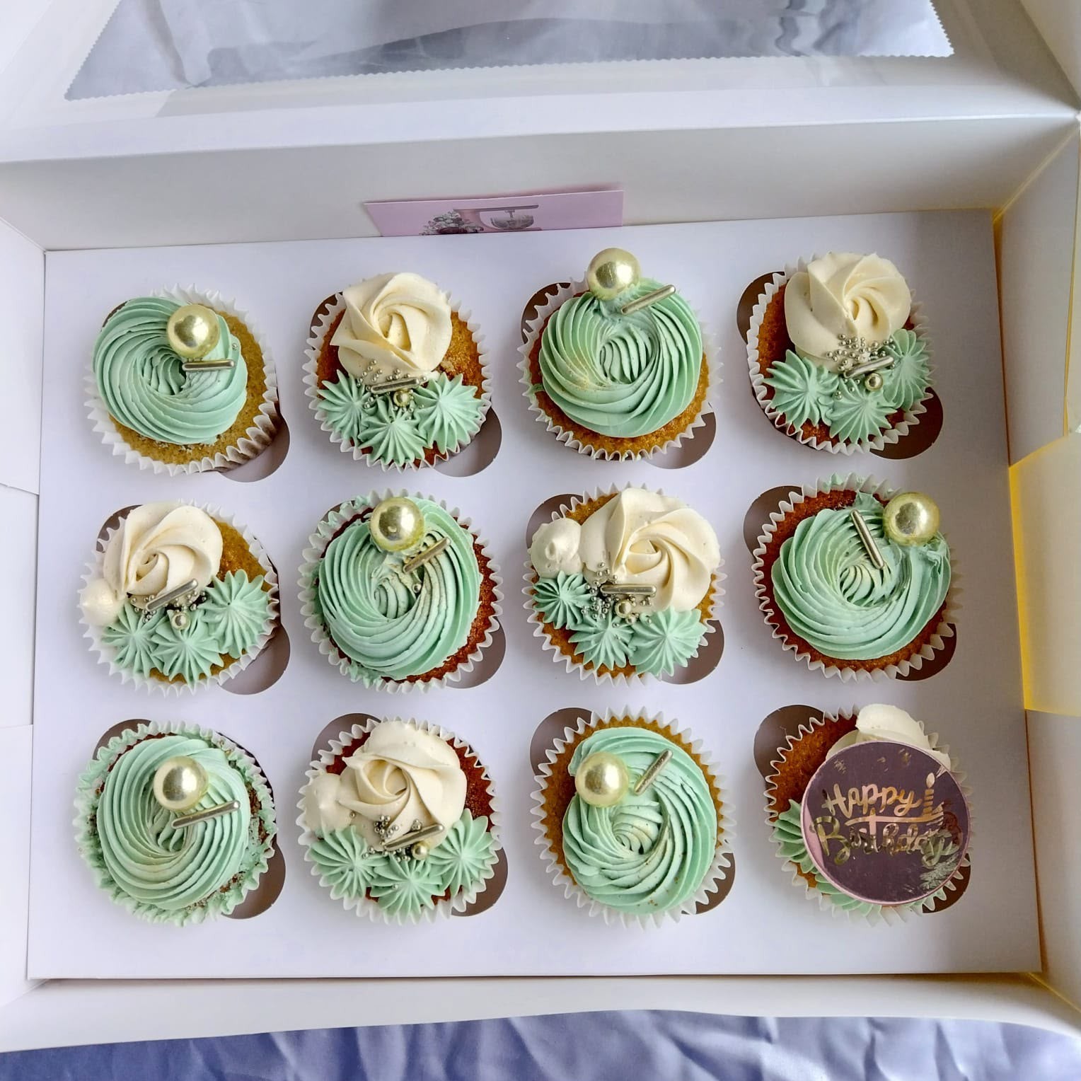 Cupcakes with mint green and white frosting and gold pearls
