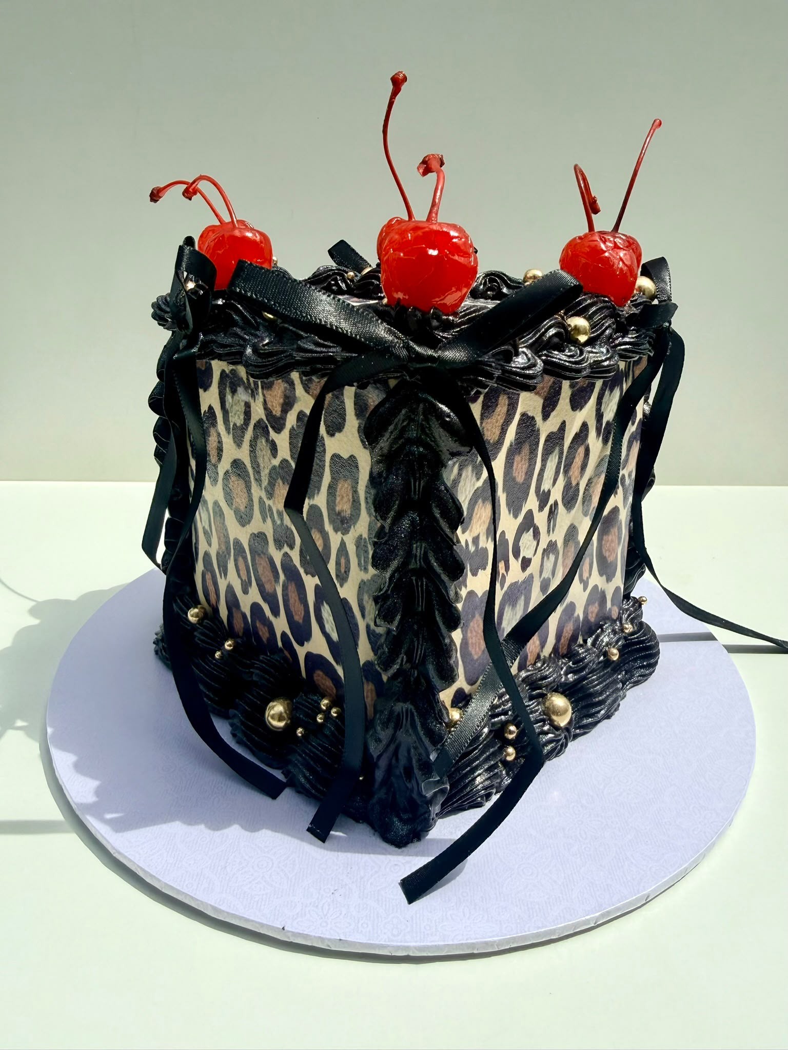 Leopard print cake with black bows and cherries